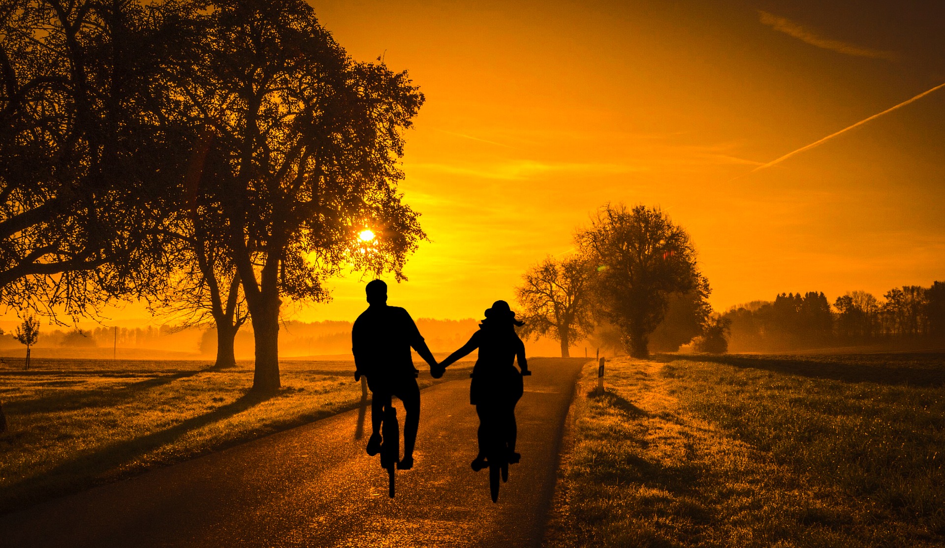 Couple cycling into the sunset